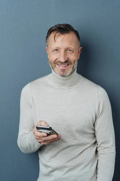 Ler Livlig Medelålders Man Stående Inne Kameran Med Mobil Handen — Stockfoto