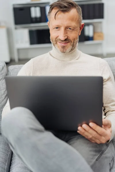 Homem Sentado Relaxando Casa Com Seu Laptop Sofá Confortável Sorrindo — Fotografia de Stock