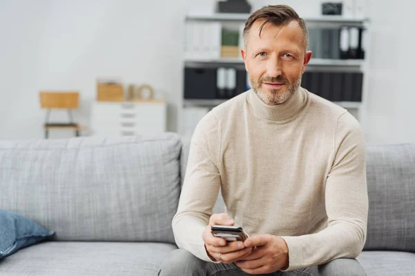 Attraktiv Mogen Bearded Man Avkopplande Hemma Soffa Sitter Håller Smartphone — Stockfoto