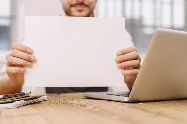 Homem segurando folha de papel em branco — Fotografia de Stock