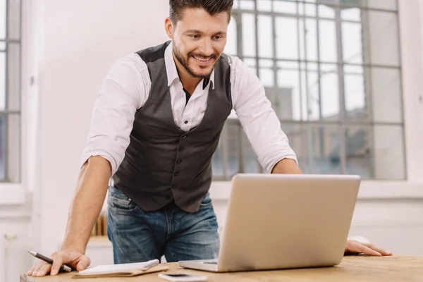 Homme souriant travaillant avec un ordinateur portable — Photo