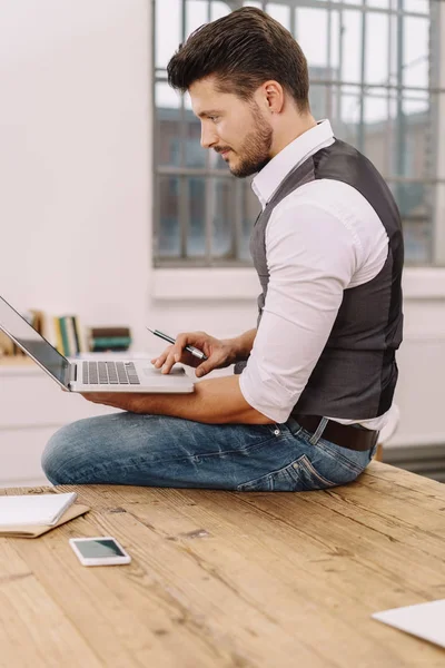 Affärsman som sitter uppe på sitt skrivbord — Stockfoto