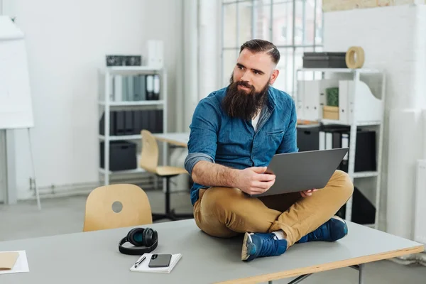 Skäggig Man Sitter Skrivbord Medan Arbetar Med Laptop Kontoret — Stockfoto