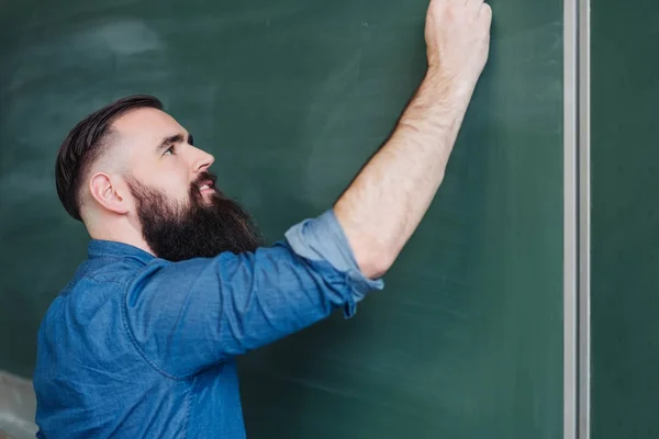 Γενειοφόρος Νέος Αρσενικό Δάσκαλο Εγγράφως Σχετικά Έναν Κενό Πίνακα Κιμωλίας — Φωτογραφία Αρχείου