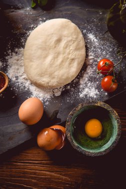 Ev yapımı pizza hazırlama ahşap masa üzerinde un ile hamur