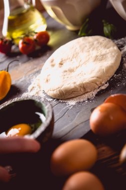 Evde pizza malzemelerle ahşap masa üzerinde hazırlanıyor