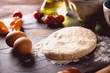 Evde pizza malzemelerle ahşap masa üzerinde hazırlanıyor
