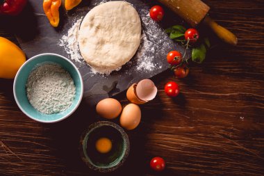 Taze ve lezzetli ev yapımı pizza malzemelerle ahşap masa üzerinde