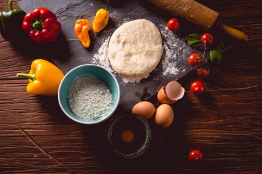 Taze ve lezzetli ev yapımı pizza malzemelerle ahşap masa üzerinde