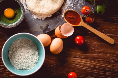Taze ve lezzetli ev yapımı pizza malzemelerle ahşap masa üzerinde