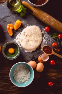 Taze ve lezzetli ev yapımı pizza malzemelerle ahşap masa üzerinde