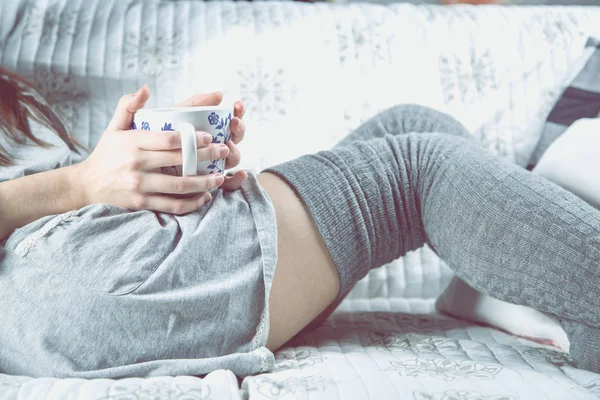 Gadis muda minum teh di sofa, konsep yang nyaman — Stok Foto