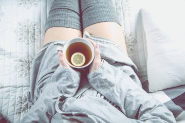Kız kanepede rahat kış konsepti sıcak çay içiyor 