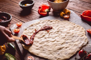 Pizza hamur ve domates soslu hazırlanıyor