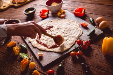 Pizza hamur ve domates soslu hazırlanıyor