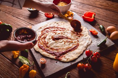 Pizza hamur ve domates soslu hazırlanıyor