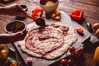 Pizza hamur ve domates soslu hazırlanıyor