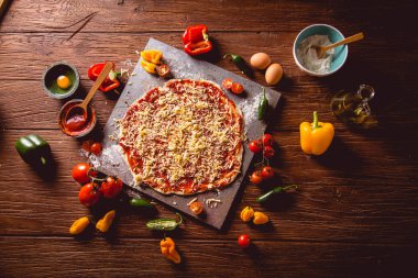 Kız ev yapımı pizza ahşap masa üzerinde hazırlanıyor