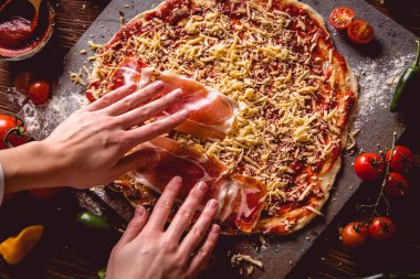 Kız ev yapımı pizza ahşap masa üzerinde hazırlanıyor