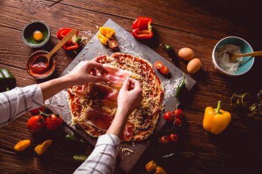 Kız ev yapımı pizza ahşap masa üzerinde hazırlanıyor