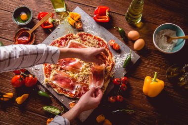 Kız ev yapımı pizza ahşap masa üzerinde hazırlanıyor