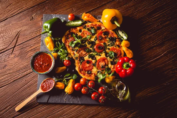 新鲜和美味的自制披萨配料与木制的桌子上 — 图库照片