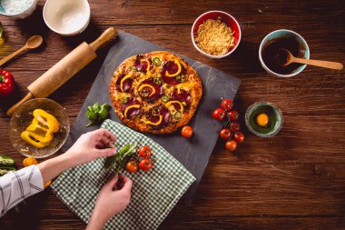 Taze ve lezzetli ev yapımı pizza malzemelerle ahşap masa üzerinde
