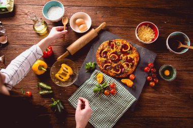 Taze ve lezzetli ev yapımı pizza malzemelerle ahşap masa üzerinde