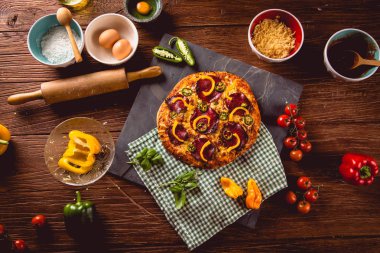 Taze ve lezzetli ev yapımı pizza malzemelerle ahşap masa üzerinde