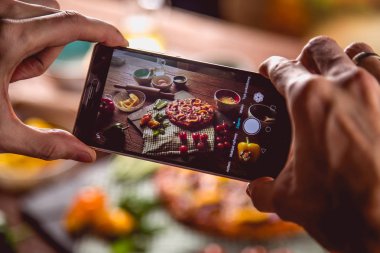 Adam ahşap masa üzerinde fotoğraf taze ve lezzetli pizza alıyor