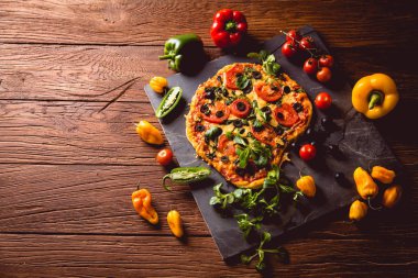 Taze ve lezzetli ev yapımı pizza malzemelerle ahşap masa üzerinde