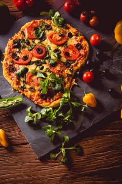 Taze ve lezzetli ev yapımı pizza malzemelerle ahşap masa üzerinde