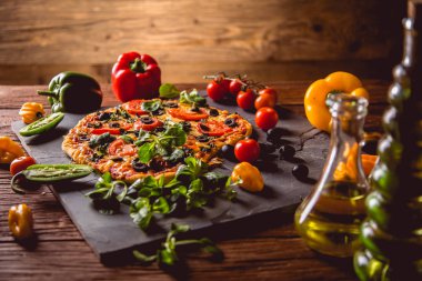 Taze ve lezzetli ev yapımı pizza malzemelerle ahşap masa üzerinde