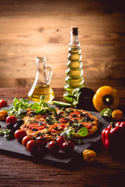 Pizza maison fraîche et savoureuse sur table en bois avec ingrédients — Photo