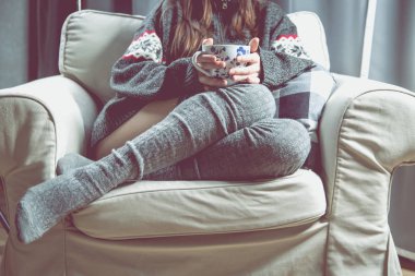 Genç kız rahatlatıcı çay ile koltuk üzerinde