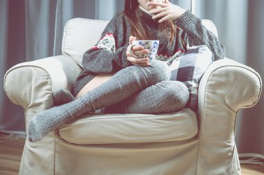 Genç kız rahatlatıcı çay ile koltuk üzerinde