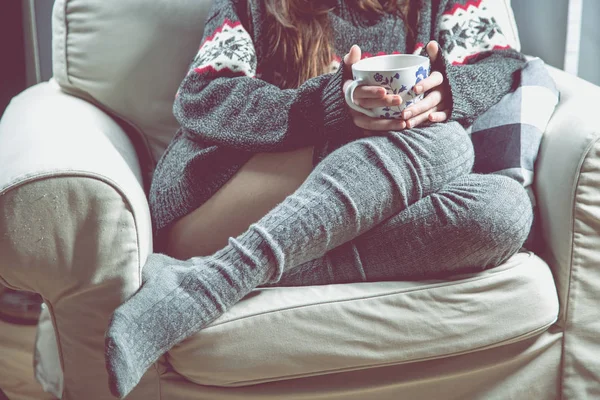 Genç kız rahatlatıcı çay ile koltuk üzerinde