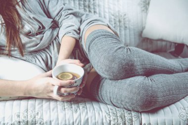 Genç kız kanepede rahat kavramı çay içiyor