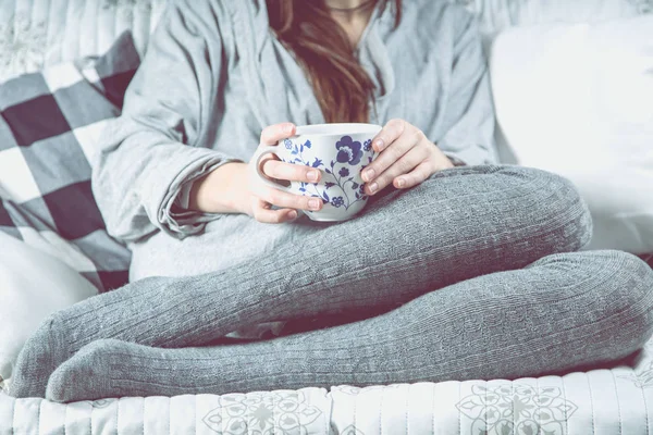 Lány a pihentető a kanapéra, a tea, hangulatos téli-koncepció — Stock Fotó