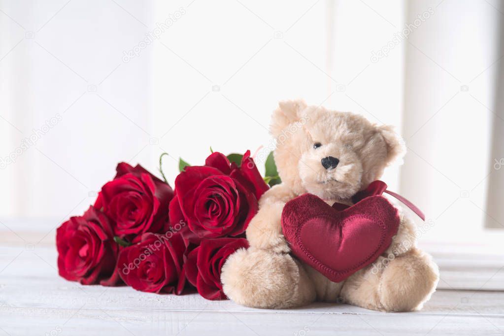 Cute valentine's teddy bear with red roses, love concept