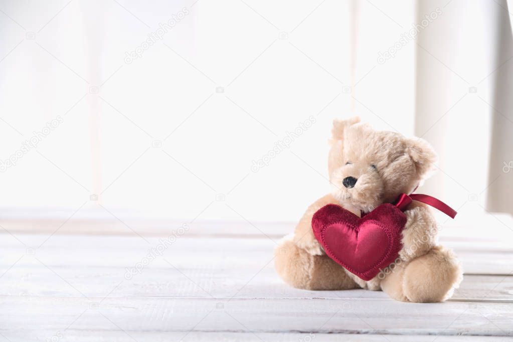 Cute valentine's  bear on bright wooden background