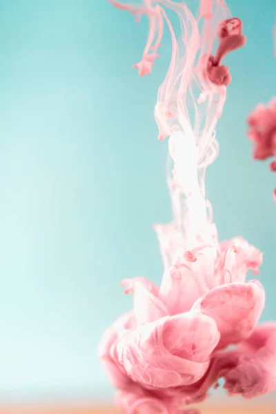 Tinta rosa na água, tiro artístico, fundo abstrato Fotografia De Stock