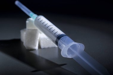 şeker ile bir şırınga yumru şeker üzerindedir. şeker ve diyabete bağımlılık kavramı