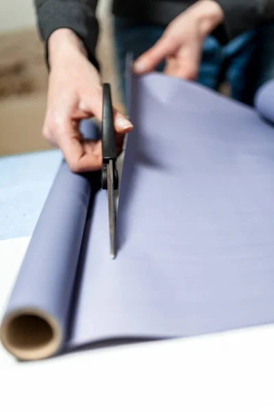 Çiçekçi ambalaj kağıdını keser. Bir buket için paket oluşturma süreci
