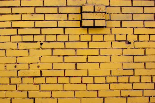 old yellow brick wall with ledge. background texture