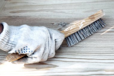 Ahşap arka planda elinde metal fırça