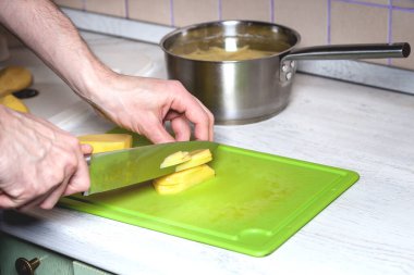 adam dilimler halinde çiğ patates keser