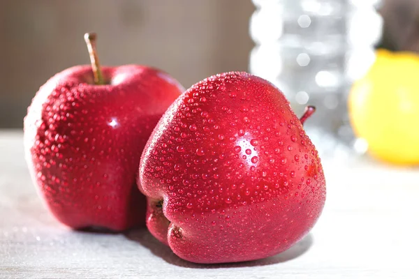 Dvě Červená Jablka Bílém Stole Vedle Láhve Vodou Citronem — Stock fotografie