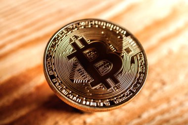 hafif ahşap zemin üzerinde bir altın sikke bitcoin