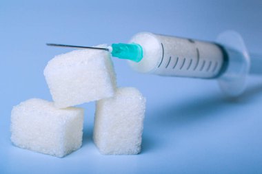 Şeker dolu şırınga şeker parçalarının üzerinde.